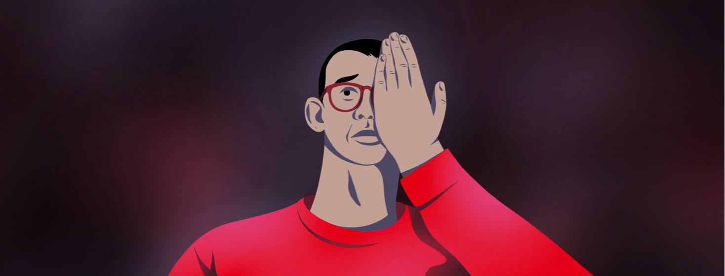 A worried man wearing glasses covers one eye with his hand.